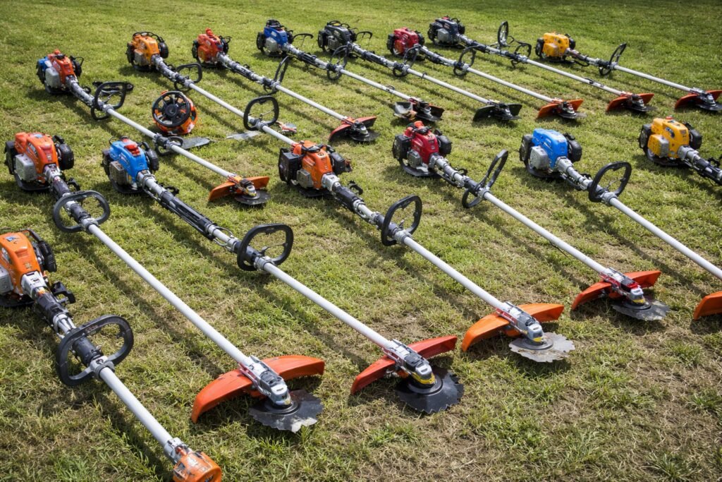 melhor roçadeira para cortar grama e mato alto em área de jardim com vários modelos de roçadeiras alinhadas